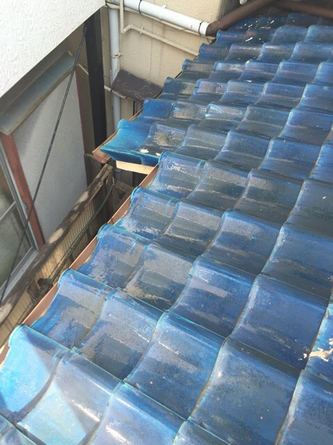 壁際の瓦の隙間がボンド（コーキング）で完全に塞がれ、雨水の逃げ道がなくなった状態。