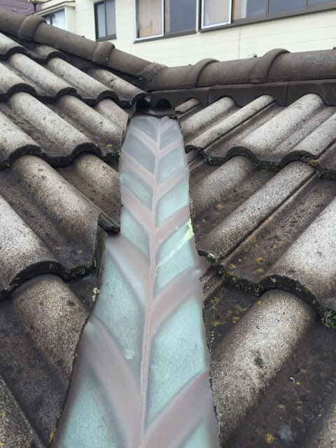 谷板金とモニエル瓦の取り合い部分。部分的な補修が難しく、全体的な改修が必要な状態。