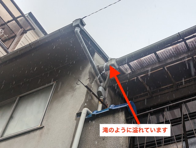 雨樋から水が滝のように流れ出している