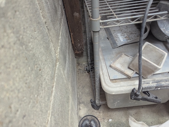 根元が腐朽しコンクリートブロックから完全に離脱している柱のアップ画像