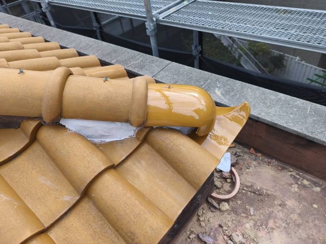 長岡京市でS瓦の差し替え工事が完了。新しい巴瓦が漆喰でしっかりと固定され、既存の屋根と違和感なく馴染んでいる様子（側面）。