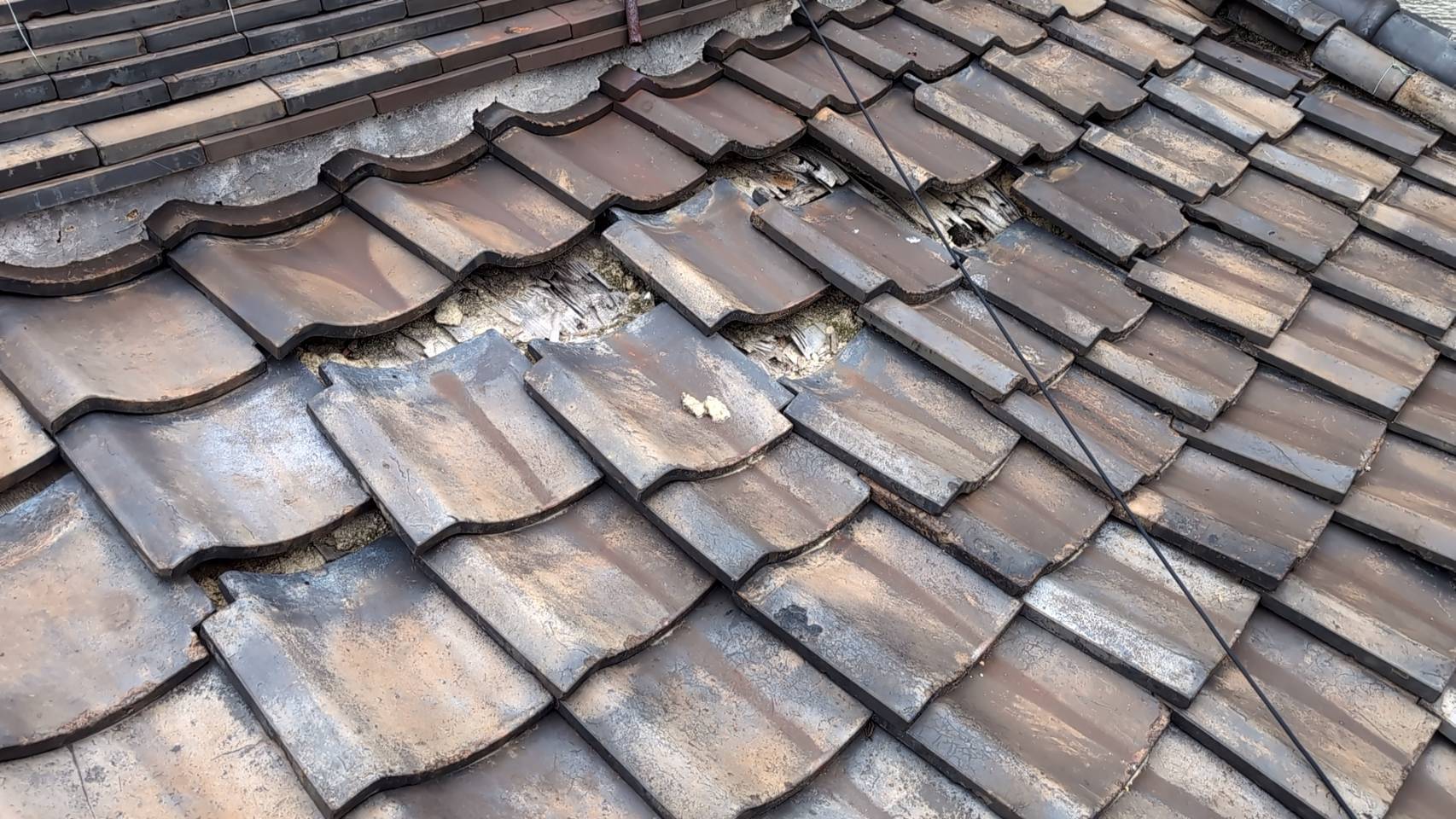 いぶし瓦が激しくずれて下地が見えている