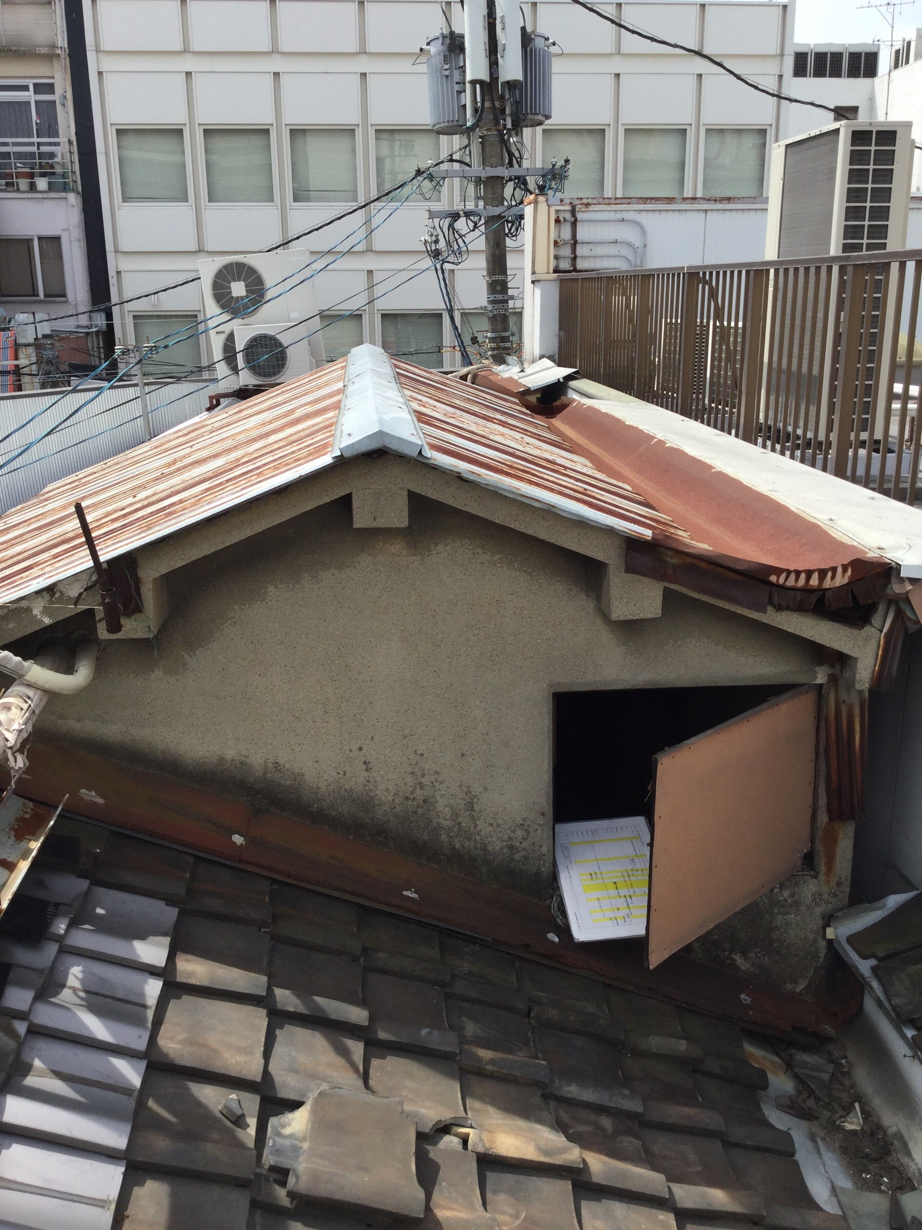 激しく錆びついたトタン屋根と金属笠木の劣化状況