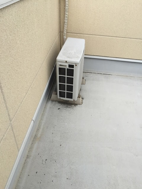 京都府八幡市のベランダにあるエアコン室外機。防水工事の際は専用台で浮かせて下までしっかり塗装します。