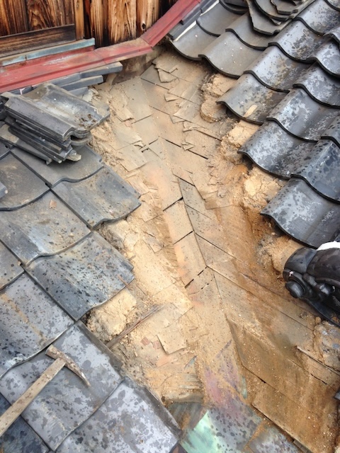 谷周辺の瓦を一時撤去し、下地の清掃と防水確認を行う工程