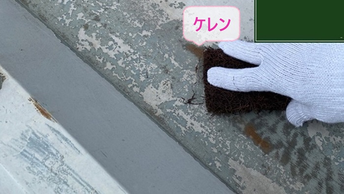 神戸市東灘区のメンテナンス工事で折半屋根にケレン作業している様子