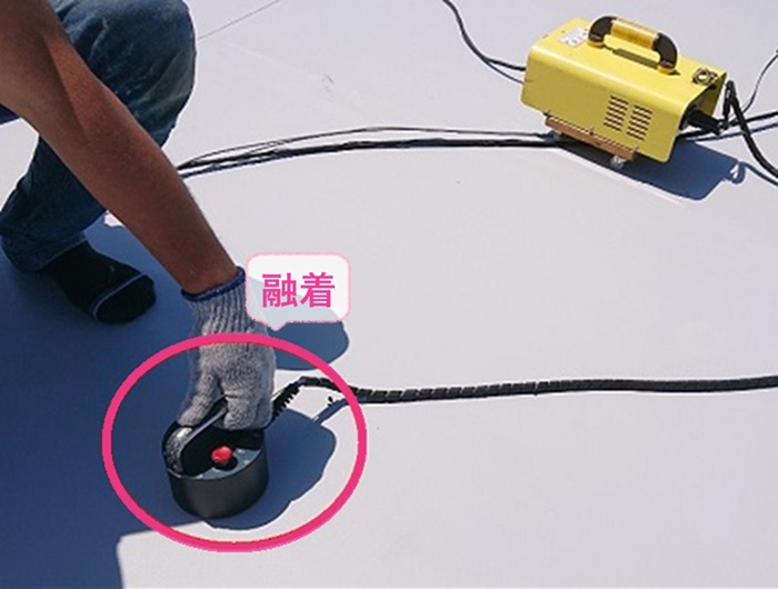 陸屋根の防水リニューアルでビュートップシートを専用の機械で融着している様子
