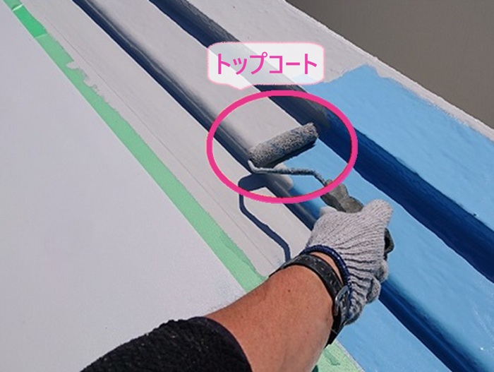 陸屋根の防水リニューアルで立ち上がり部分にトップコートを塗っている様子