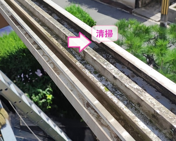 テラス屋根のポリカ板交換で雨樋を掃除している様子