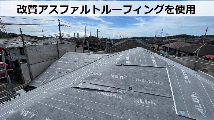 天窓付きカラーベスト屋根へのカバー工事で改質アスファルトルーフィングを貼っている様子
