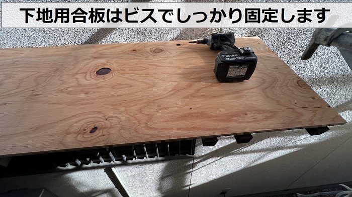 庇屋根の貼り替えで下地用合板をビスで固定している様子