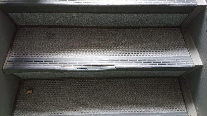 明石市で共用階段のステップシートが剥がれている様子