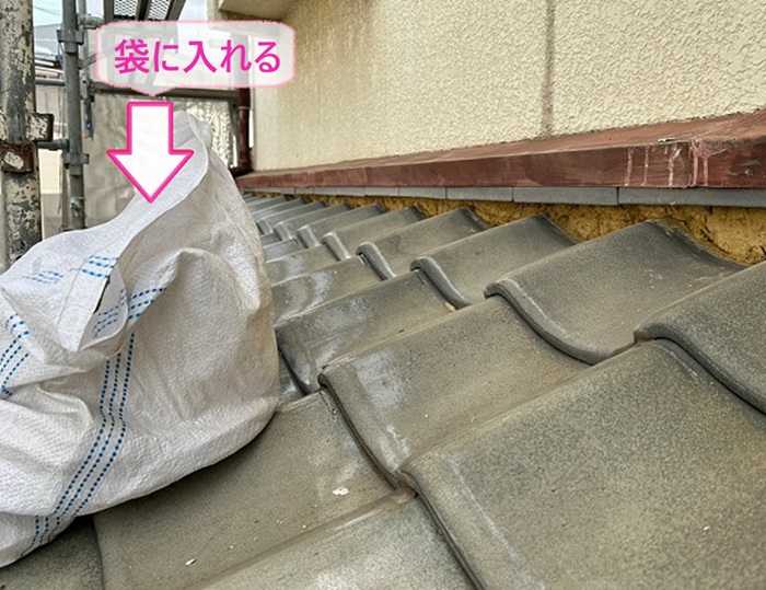 瓦屋根のメンテナンスで撤去した漆喰を袋に入れながら作業している様子