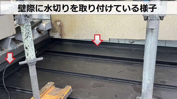 玄関屋根の壁際に水切りを取り付けている様子