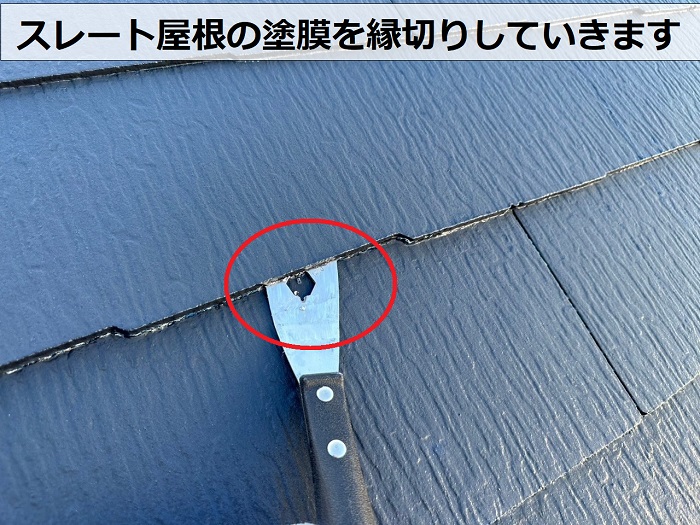 スレート屋根の塗膜を縁切りしている様子