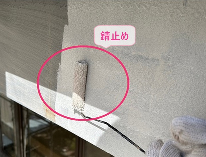 テナント建物の鼻隠し塗り替えで板金製の破風板に錆止めを塗っている様子