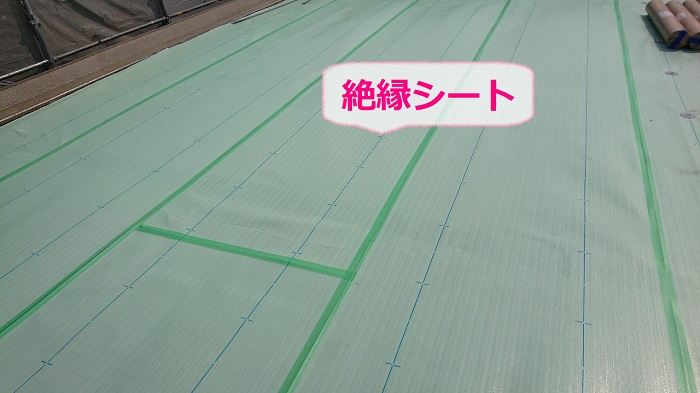 塩ビシート防水機械固定工法で絶縁シートを貼っている様子