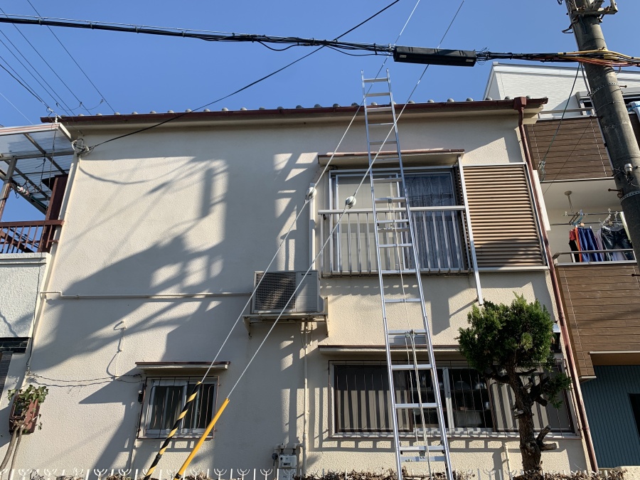 瓦屋根に梯子を掛けている様子