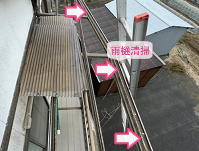 ベランダ屋根の波板交換で雨樋内部を掃除している様子