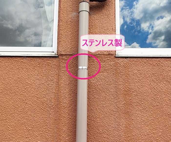 店舗建物の雨樋部分取り替え工事でステンレス製のバンドで固定している様子