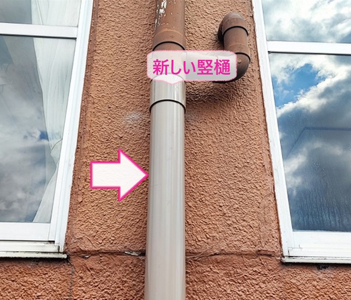 店舗建物の雨樋部分取り替えで新しい竪樋を接合している様子