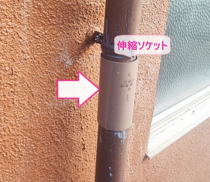 店舗建物の雨樋部分取り替え工事で伸縮ソケットを取り付けている様子