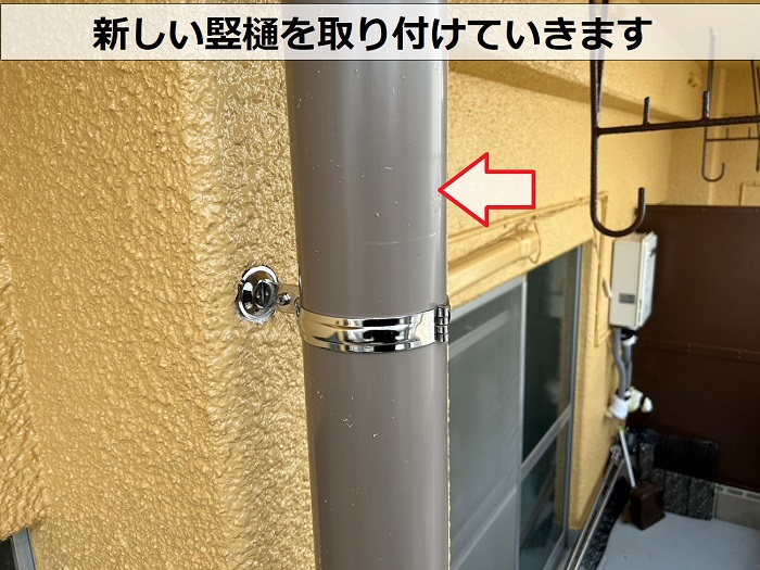 3階建てマンションで新しい竪樋を取り付けている様子
