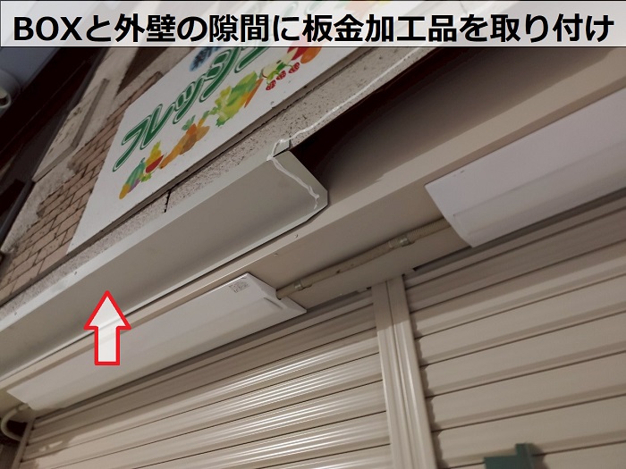 神戸市灘区の商店街で手動式2分割シャッター交換の費用紹介をする現場で板金取り付け