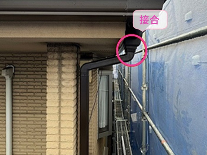 雹で壊れた樹脂製雨どいの取り替えで集水器と竪樋を接合している様子