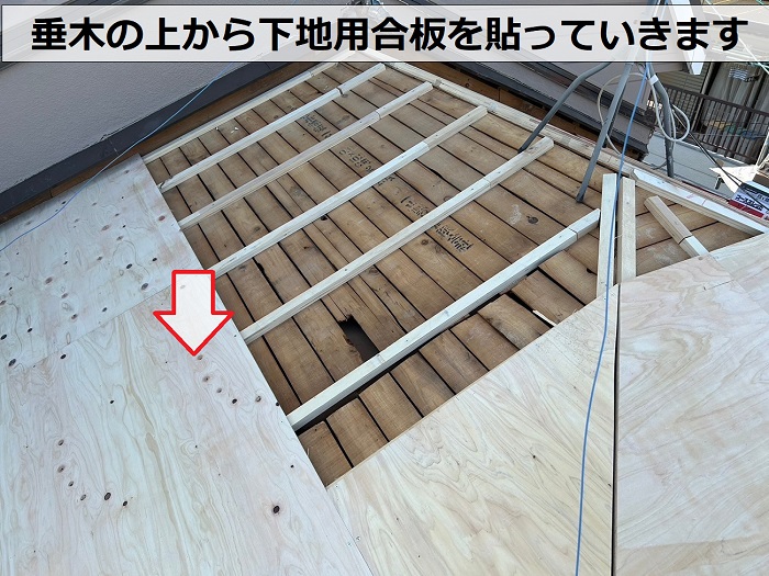 垂木の上から下地用合板を貼っている様子