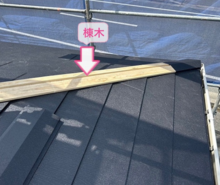 古い化粧スレートの重ね葺き工事で棟木を取り付けている様子