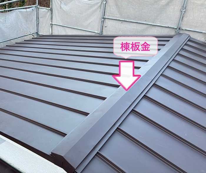 波型スレート屋根の葺き替え工事で棟板金を取り付けている様子