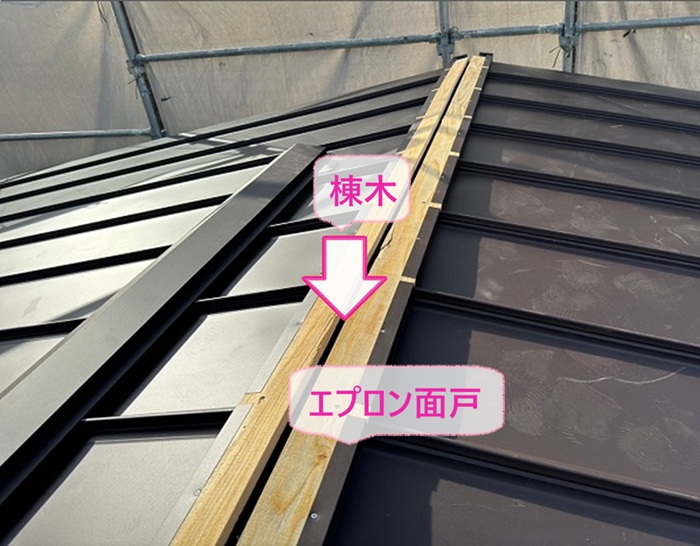 波型スレート屋根の葺き替え工事で棟の部分に棟木とエプロン面戸を取り付けている様子