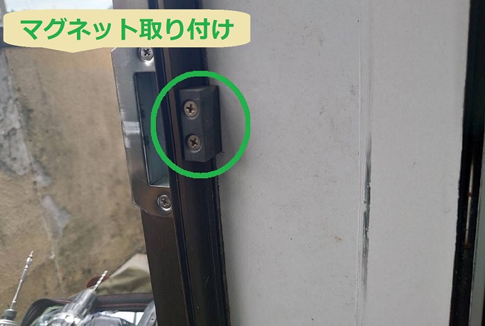 宝塚市で飲食店の厨房にあるアルミ製の勝手口へ網戸を後付けする現場でマグネット取り付け