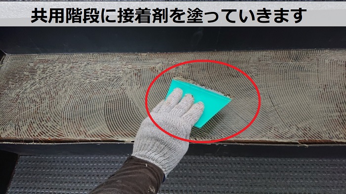 芦屋市の4階建てハイツの共用階段に接着剤を塗っている様子