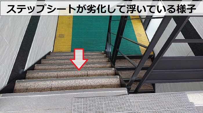 4階建てハイツの共用階段に貼られたステップシートが浮いている様子