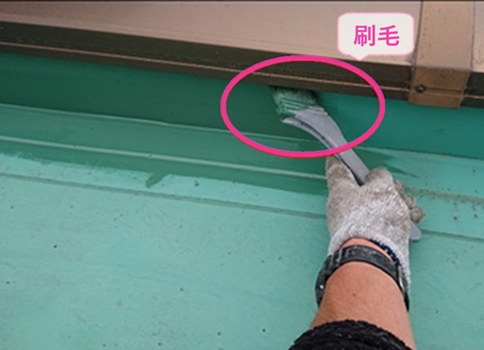 ゴムシート防水の保護塗装で狭い部分には刷毛を使ってトップコートを塗っている様子