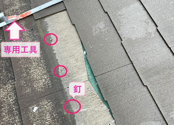 ひび割れたカラーベストの固定釘を専用工具を使用して外している様子