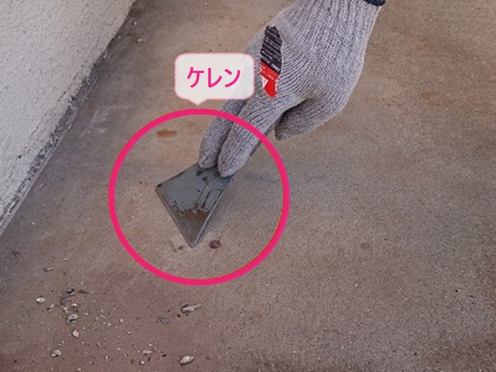 クラック対策をする防水工事で既存のベランダ床をケレンしている様子