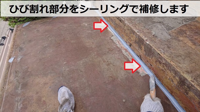 庇屋根のひび割れ部分をシーリングで補修している様子