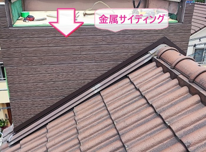 神戸市東灘区の屋根板金修理で木目調の金属サイディングを貼っている様子