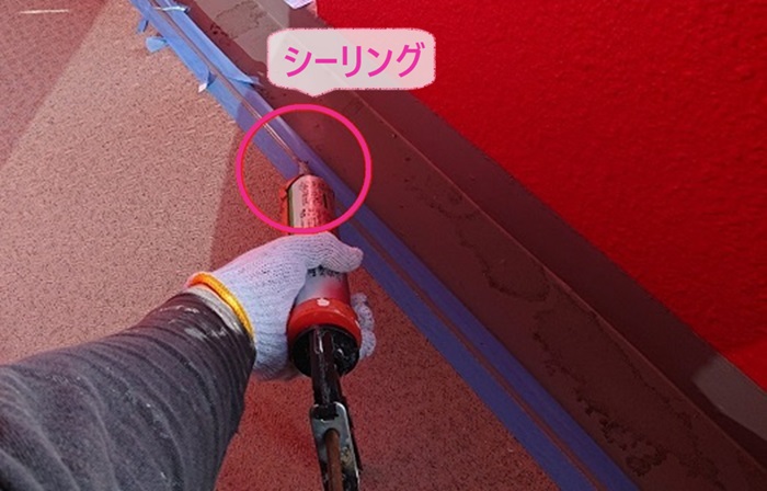 外部階段、廊下のメンテナンス工事で長尺シートの端部にシーリングを打っている様子