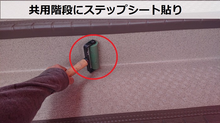 共用階段にステップシートを貼っている様子