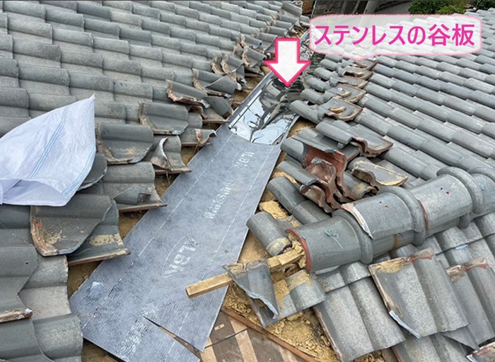 陶器瓦屋根の劣化補修でステンレス製の谷板を取り付けている様子