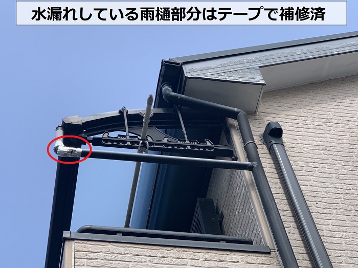 水漏れしている雨樋にテープで補修している様子
