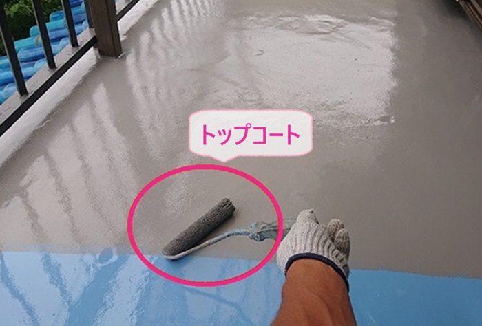 ベランダへのウレタン防水工事でトップコートを塗っている様子