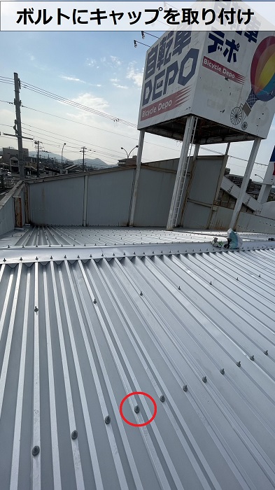 折半屋根のボルトにキャップを取り付けている様子