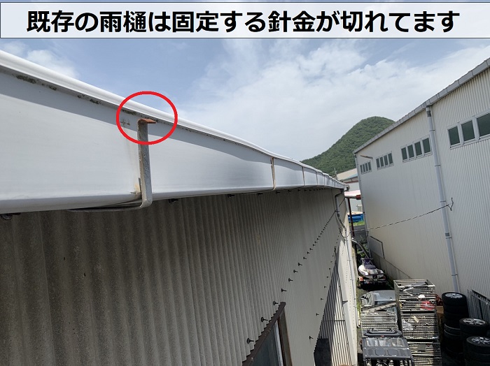 工場の雨樋は固定する針金が切れている様子