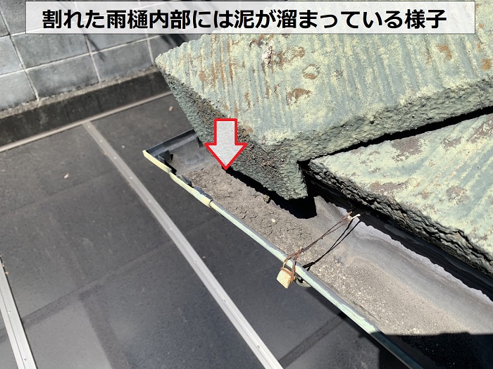 水漏れしている雨樋の内部には泥が溜まっている様子