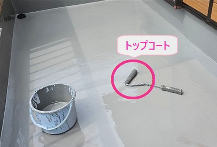 ひび割れのあるコンクリート防水工事でトップコートを塗っている様子